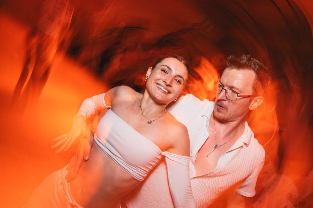 Couple de danseurs saisi dans un mouvement lumineux sur la piste